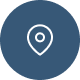 A white map pin location icon centered on a blue circular background.